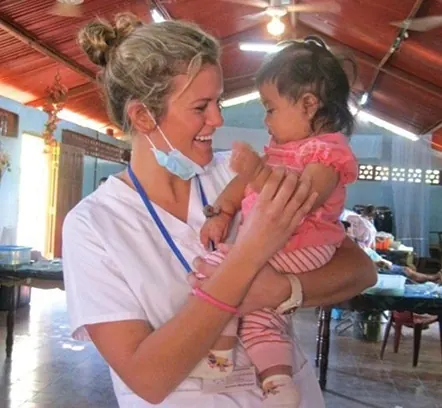 Dr. Amiee with a patient&rsquo;s baby on a service trip to Nicaragua.